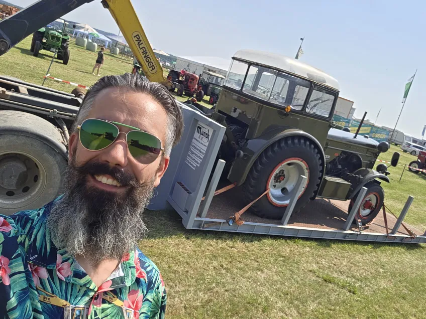 Ingo Faber vor einem LKW der einen Traktor ablädt