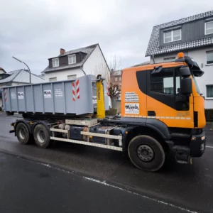Containerfahrzeug mit geladenem Container am Straßenrand